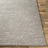 Close-up of the hand woven Cirencester Area Rug showing its ivory and medium gray braided wool and viscose texture. Front