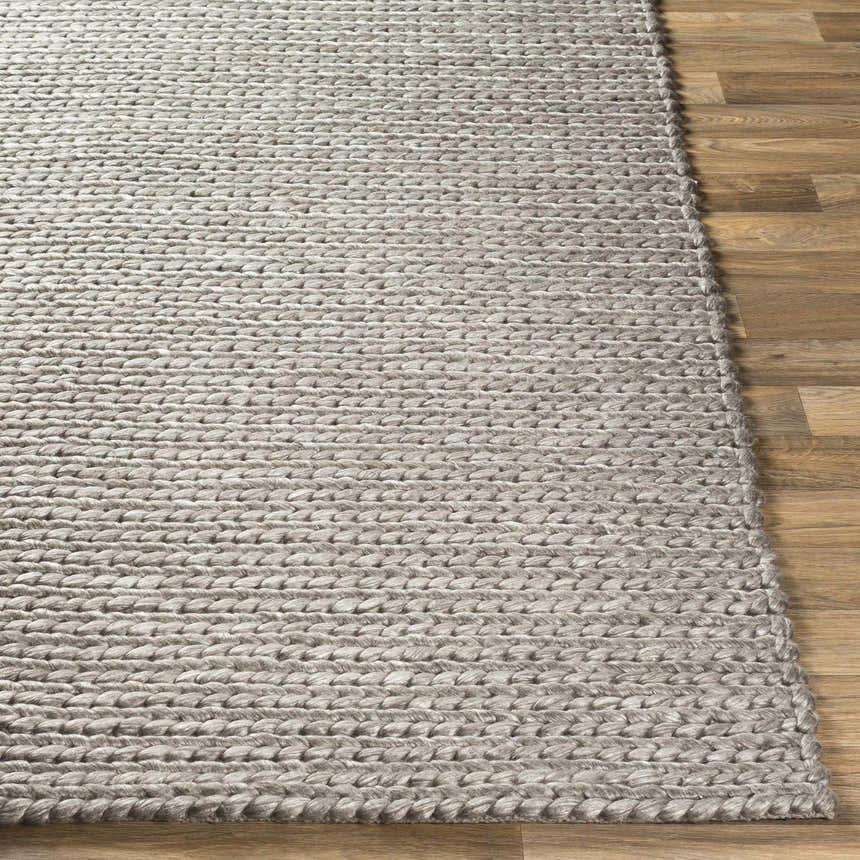 Close-up of the hand woven Cirencester Area Rug showing its ivory and medium gray braided wool and viscose texture. Front