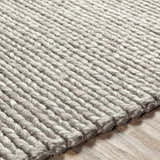 Close-up of the hand woven Cirencester Area Rug in medium gray and ivory, showing texture and wool blend. Texture