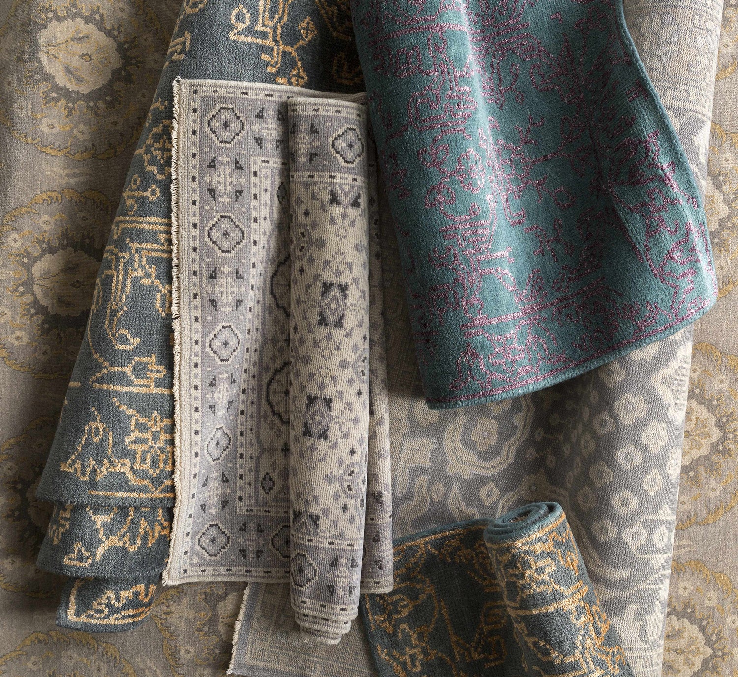 Close-up of rolled Redvale Area Rug in burgundy, teal, and gray. Hand-knotted wool and viscose rug with contemporary design. Styleshot