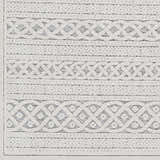 Close-up of the Clenchwarton Textured Beige Rug. Features light beige and charcoal geometric patterns and woven texture. Swatch