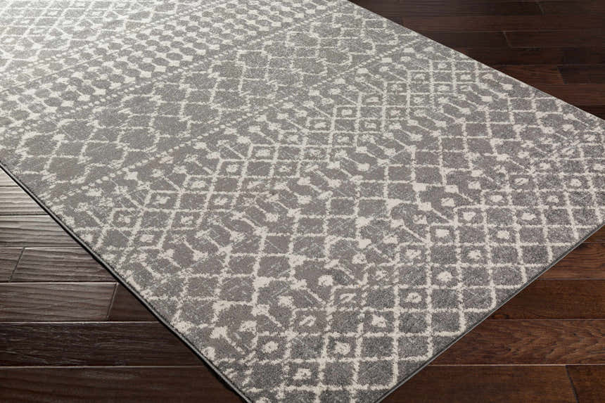 Close-up of the Cliffwood Area Rug. Charcoal and light beige geometric pattern. Contemporary style. Corner