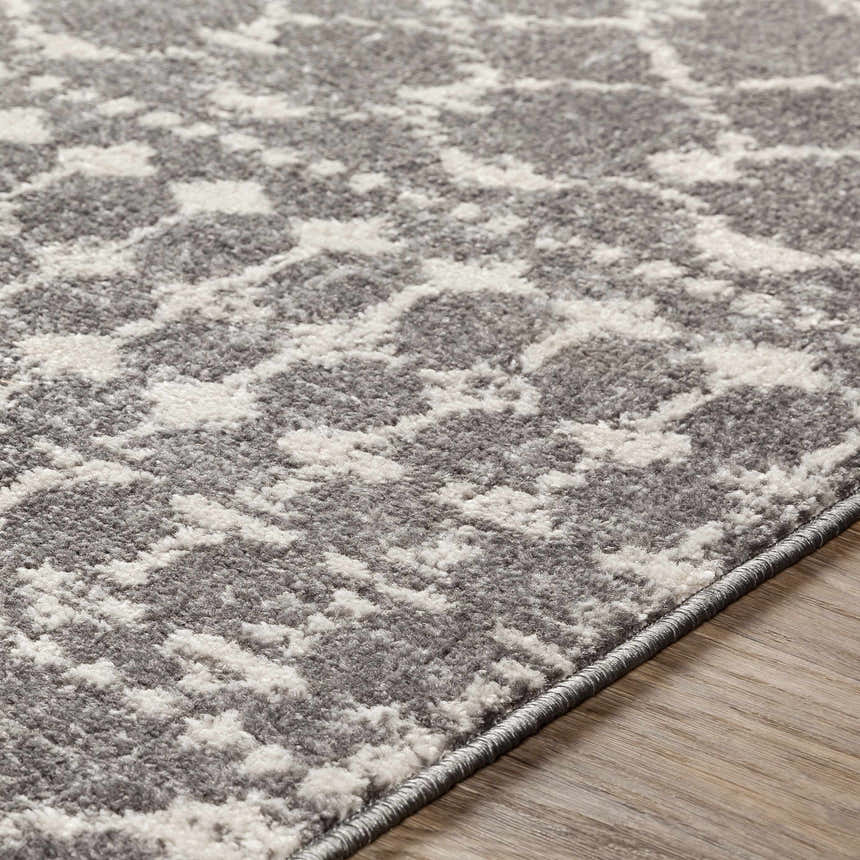 Close-up of the Cliffwood Area Rug. Charcoal, gray, and light beige abstract pattern. Machine woven texture. Texture