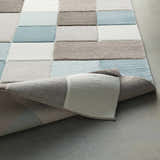 Close up of the Clinton Area Rug showing aqua, ivory, taupe, and dark brown color blocks and soft texture. Fold