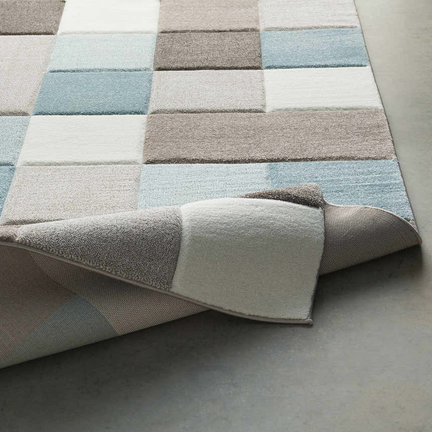 Close up of the Clinton Area Rug showing aqua, ivory, taupe, and dark brown color blocks and soft texture. Fold