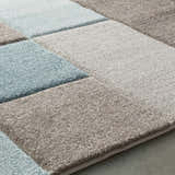 Close-up of the Clinton Area Rug, a contemporary rug with aqua, brown, ivory, and taupe square pattern. Texture