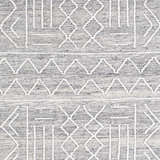 Close-up of Gray Clintwood Wool Tassel Carpet showing geometric white pattern on charcoal, cream, and oatmeal woven texture. Swatch