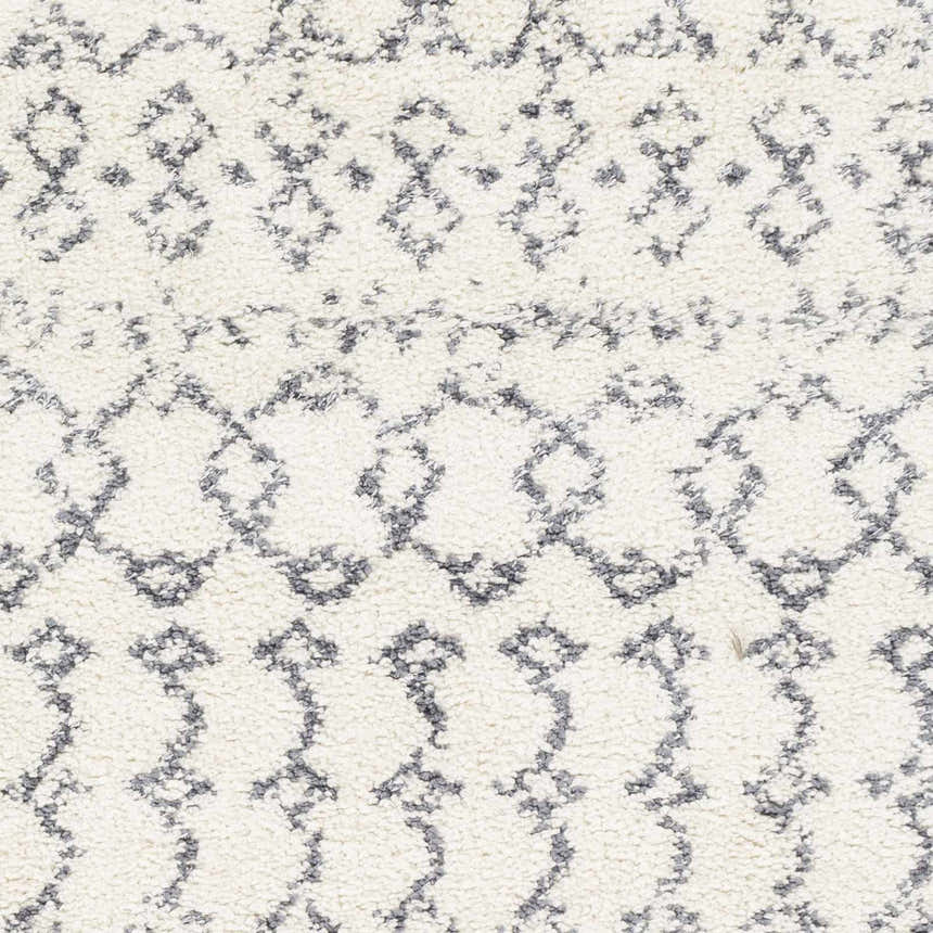 Close-up of the shag Clarkia Area Rug in white with gray geometric patterns. Bohemian style. Swatch