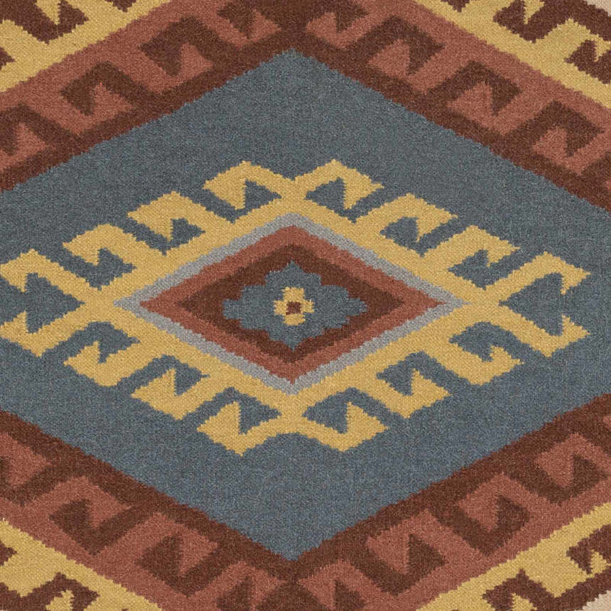 Close up of the Clutier Clearance Rug. Hand woven wool rug with beige, blue, brown, mustard, and rose geometric design. Swatch
