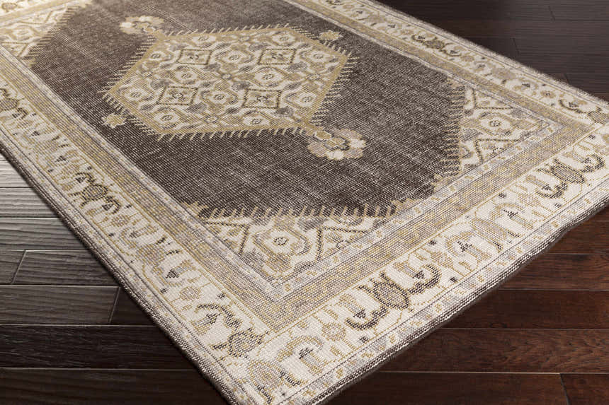 Close-up of the brown and off-white Clyo Carpet, a hand-knotted wool rug with a traditional design. Corner