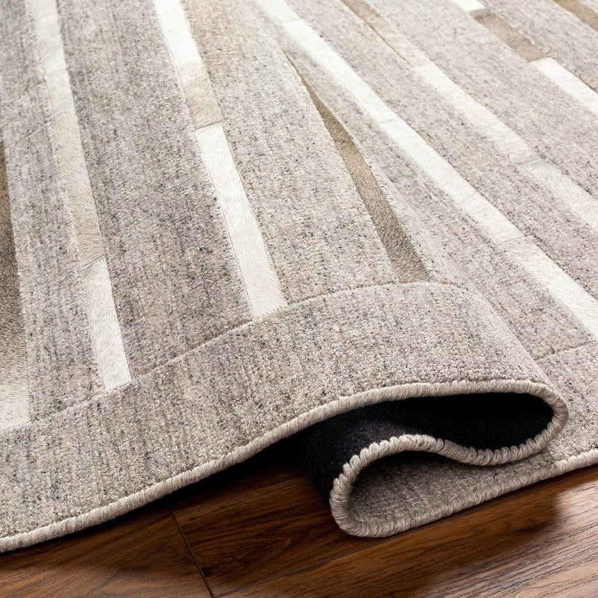 Close-up of the Cantu Premium Viscose&Leather Area Rug, showcasing its geometric pattern and light beige, gray tones. Fold
