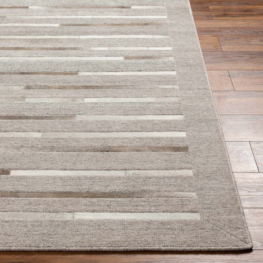 Close-up of Cantu Premium Viscose & Leather Area Rug. Beige, light gray geometric pattern. Hair on hide and leather details. Front