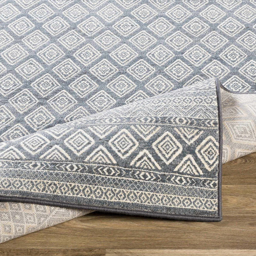 Close up of the Centertown Area Rug, featuring a blue and ivory geometric diamond pattern. Fold