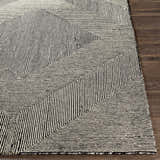 Close-up of the hand-tufted Conshohocken Area Rug. Black and cream wool rug with a modern geometric pattern. Front