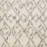 Close-up of the Cotgrave 2x3 cream trellis wool rug. Hand-woven shag texture with a geometric diamond pattern. Swatch