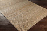 Close-up of the Buwoi Hand Woven Tan Jute Rug showing its diamond pattern and natural fiber texture on dark wood flooring. Corner
