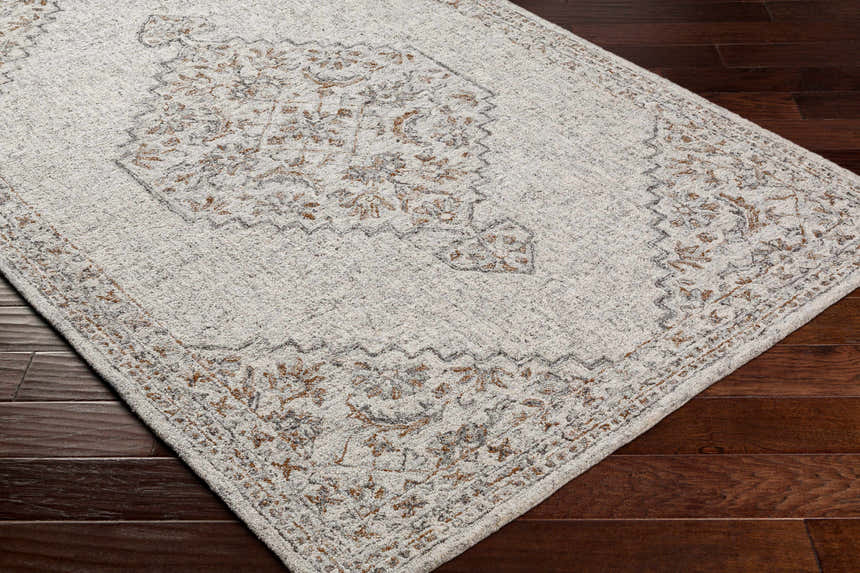 Close-up of the hand-tufted Currimao Area Carpet. Viscose rug with a traditional Persian-style design in neutral and brown tones. Corner
