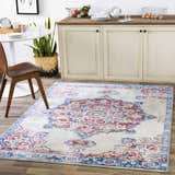 Farmhouse kitchen with Carron Area Rug in blue and red, under a round table and cream-colored cabinets. Roomscene-Rectangle