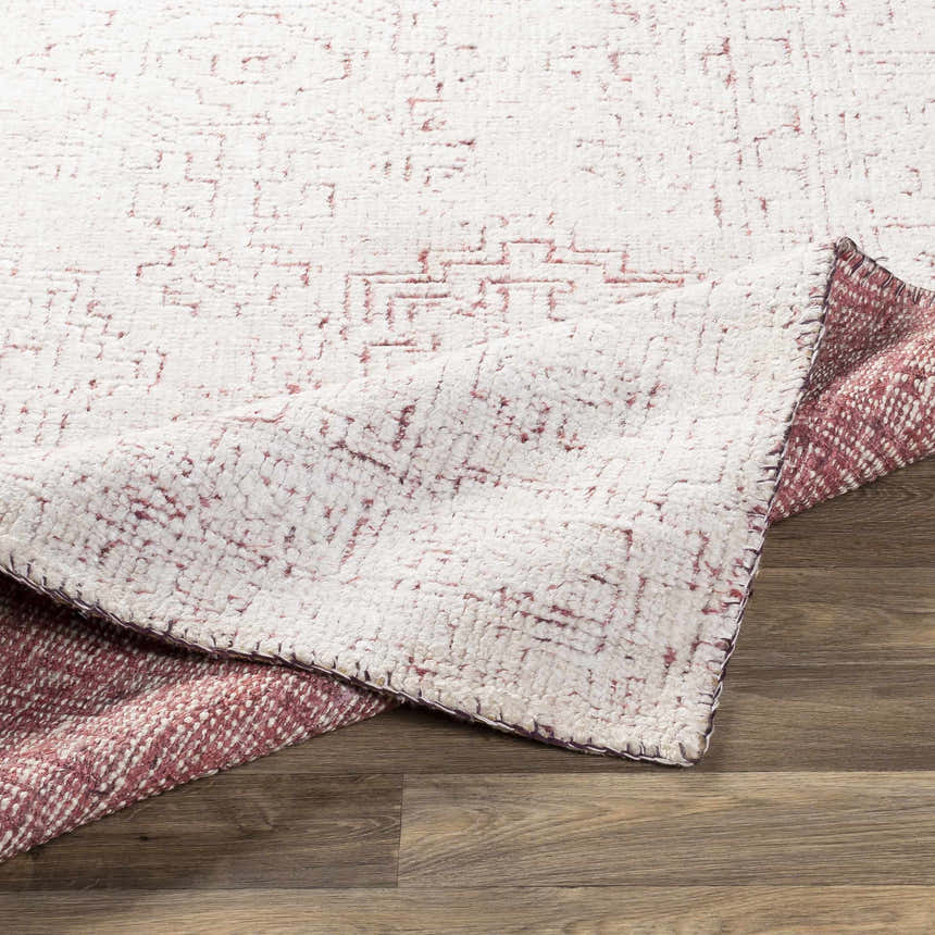Close-up of the hand-knotted Cunderdin Carpet. Mauve and white farmhouse rug with a subtle geometric pattern. Viscose texture. Fold