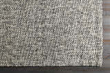 Close-up of the hand-loomed Cushendall Premium Rug. Dark blue and off-white yarns create a textured, contemporary design. Corner