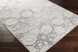 Close-up of the Cwm Area Rug showing its charcoal, light gray, and off-white contemporary floral design. Corner