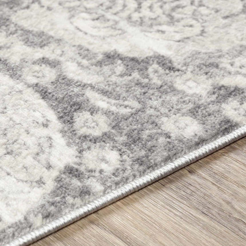 Close-up of the Cwm Area Rug showing the charcoal, light gray, and off-white contemporary pattern and machine-woven texture. Texture
