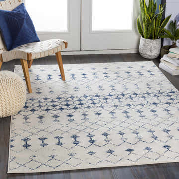 Living room scene with a white and blue geometric Cowaramup Area Rug, chair, and plants. Roomscene-Rectangle