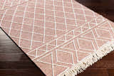 Close-up of the hand woven Dacudao Area Rug. Burgundy and cream wool rug with geometric diamond pattern and fringe. Corner