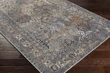 Close-up of the beige, black, and gray Dagatan Washable Area Rug with a traditional oriental pattern on dark wood floors. Corner