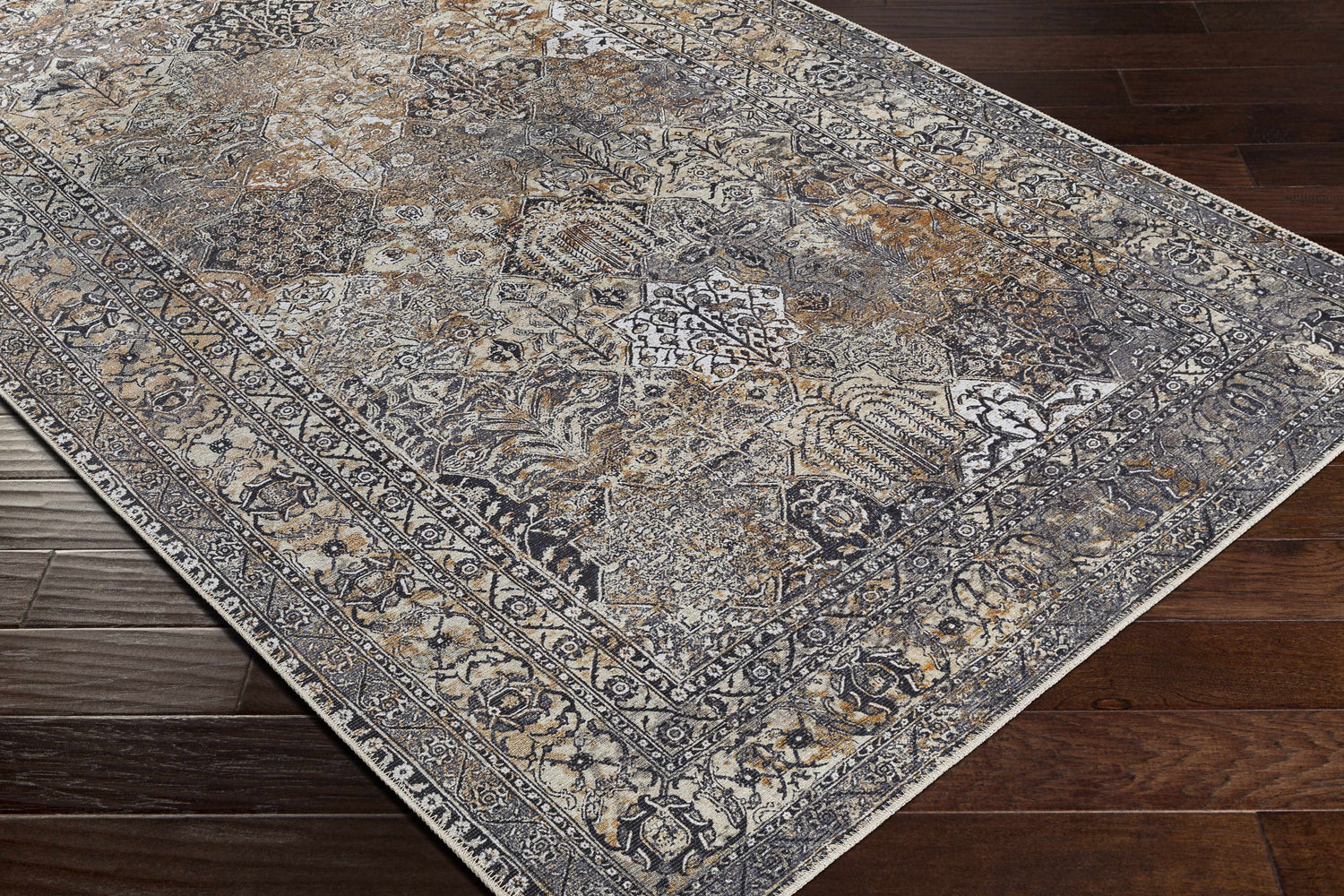 Close-up of the beige, black, and gray Dagatan Washable Area Rug with a traditional oriental pattern on dark wood floors. Corner