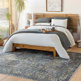 Bedroom scene with a beige, black, and gray Dagatan Washable Area Rug under a wood bed frame. Roomscene-Rectangle