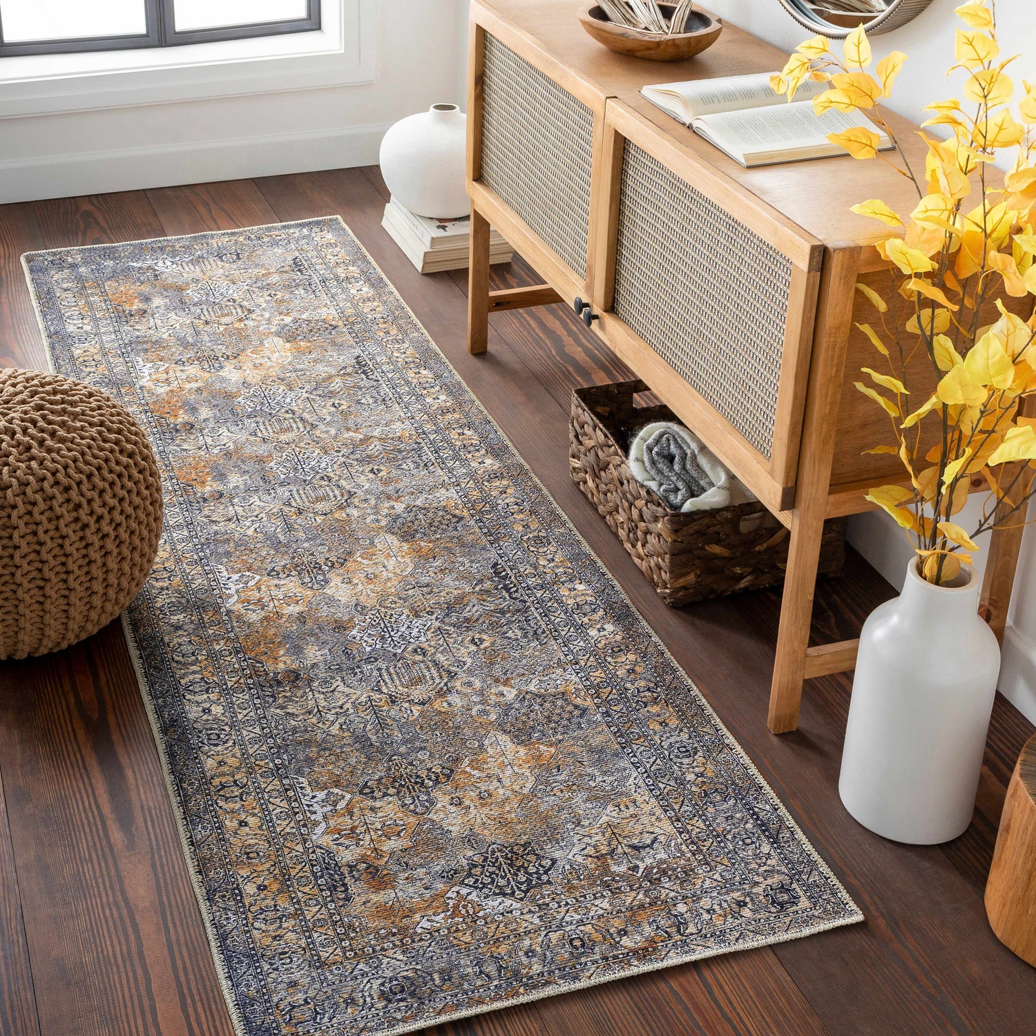 Entryway scene with a beige and black Dagatan Washable Area Rug runner, wood console table, and brown pouf. Roomscene-Runner