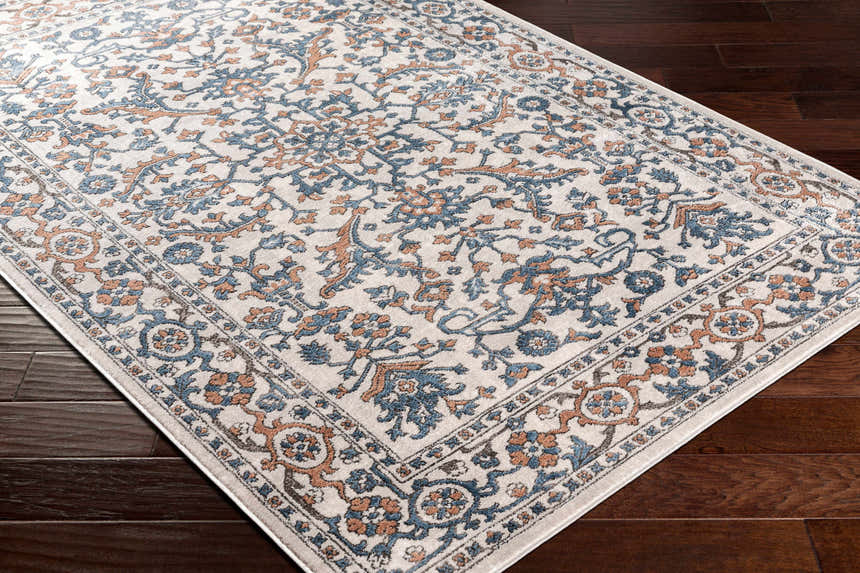 Close-up of the Dagny Area Rug showing a traditional floral pattern in cloud gray, light gray, multi brown, and taupe. Corner