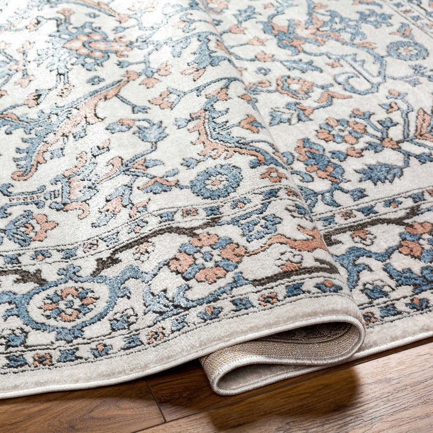 Close-up of the Dagny Area Rug showing its traditional floral pattern in cloud gray, light gray, multi brown, and nutmeg. Fold