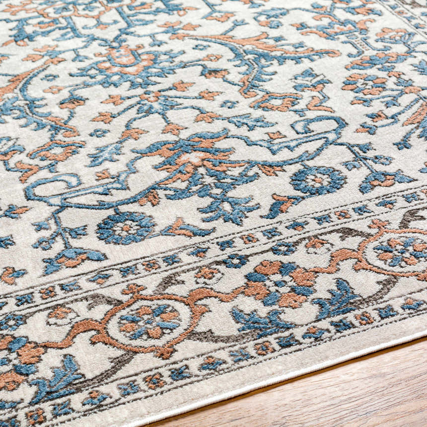 Close up of the Dagny Area Rug showing its traditional floral pattern in cloud gray, light gray, and nutmeg. Texture