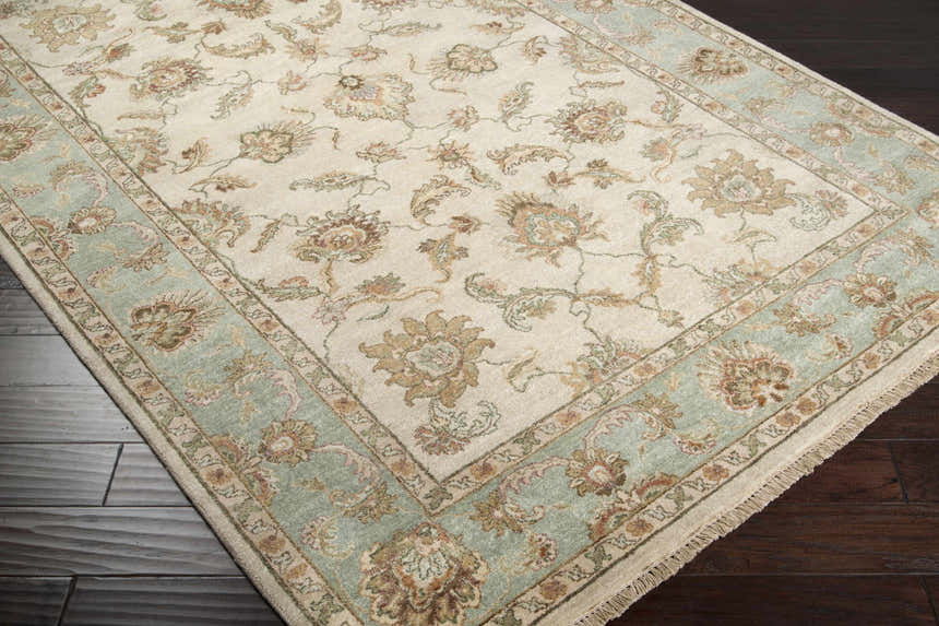 Close-up of the Dahlonega Area Carpet, a hand-knotted wool rug with beige, brown, and dusty sage floral design. Corner