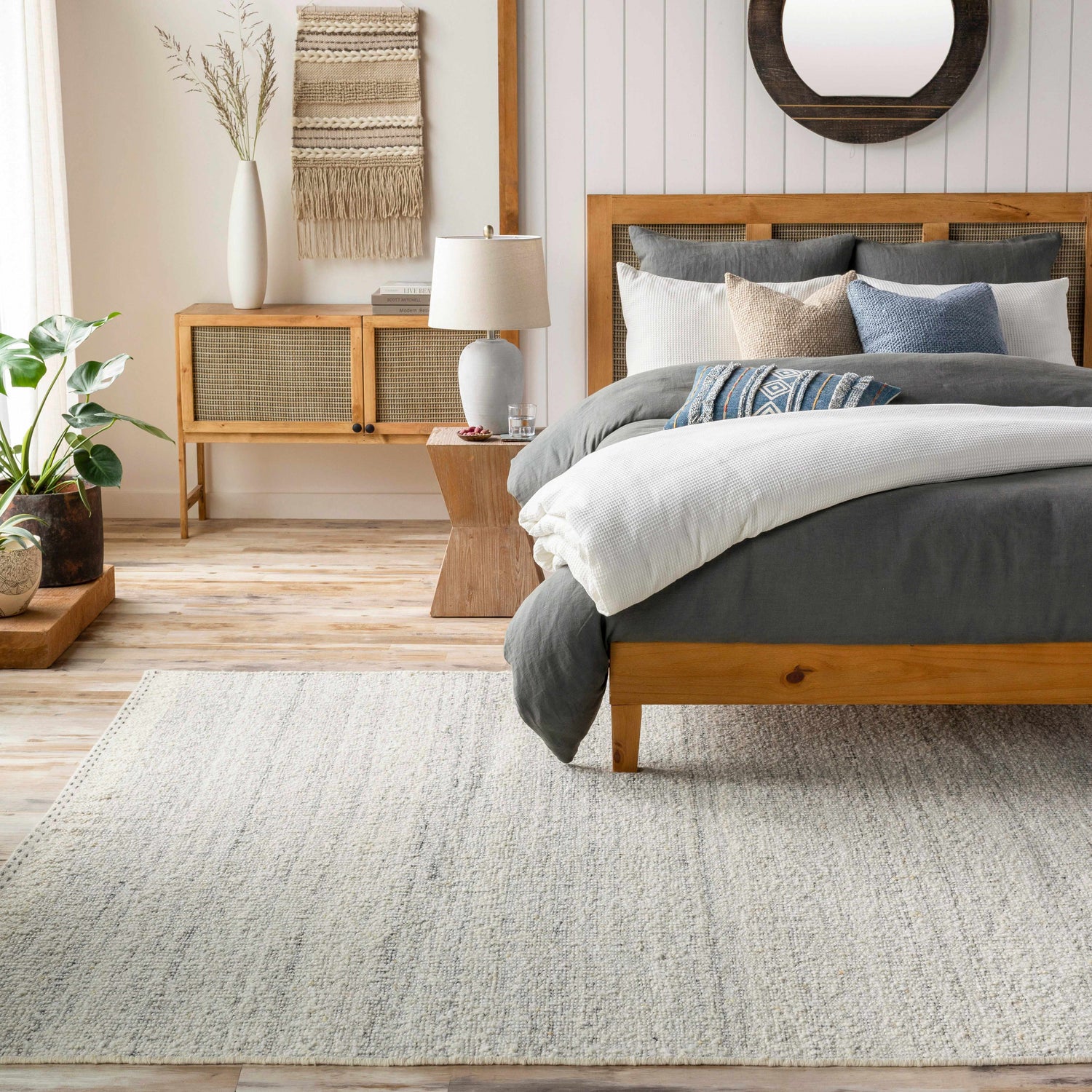 Bedroom scene with a cream Dalaoig Flat Woven Wool Rug, wood bed, and neutral decor creating a calm, transitional style. Roomscene-Rectangle