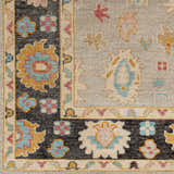 Close-up of the hand-knotted Dalupaon Area Rug. Features black, beige, blue, pink, and mustard floral and oriental patterns. Swatch