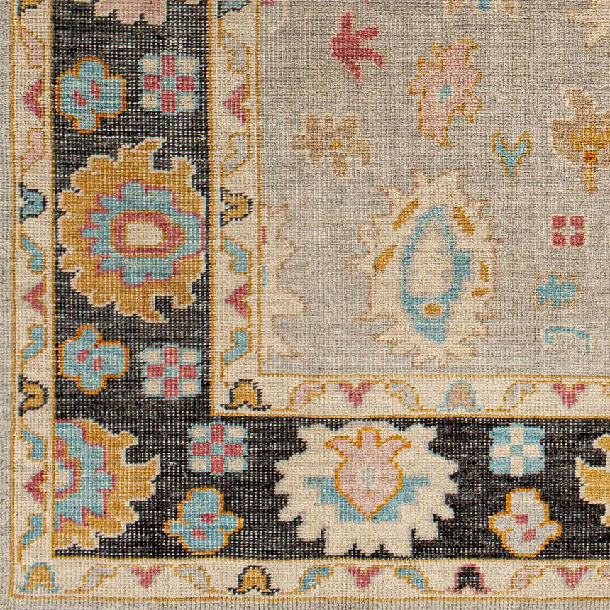 Close-up of the hand-knotted Dalupaon Area Rug. Features black, beige, blue, pink, and mustard floral and oriental patterns. Swatch