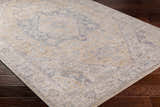 Close-up of the Deena Thick Luxe Area Rug with a traditional design in brown, charcoal, and gray on dark wood floors. Corner
