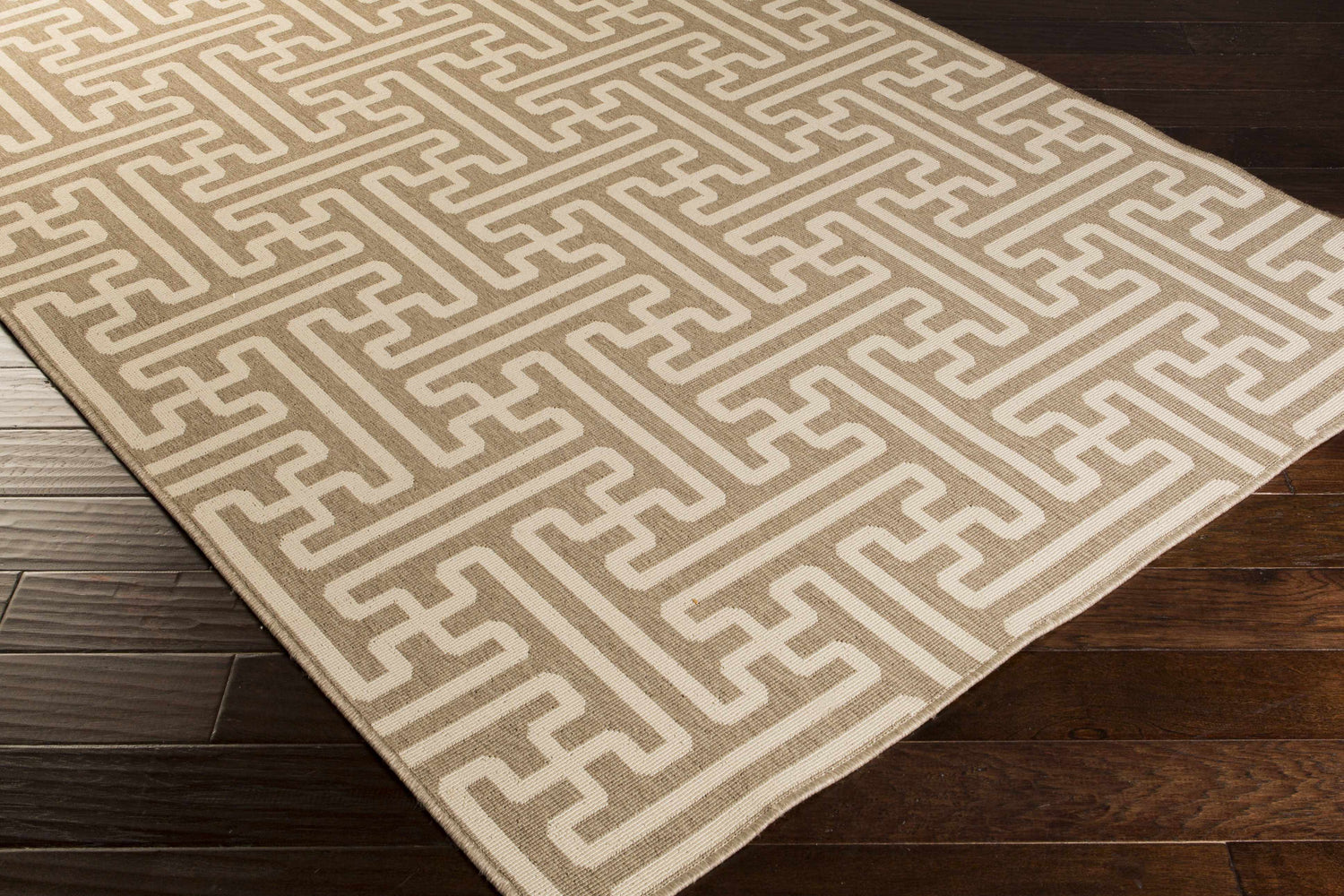 Close up of beige Divernon Area Rug with geometric maze pattern on dark wood floor. Clearance item. Corner