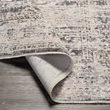 Close-up of the Divisoria Area Rug, a machine woven rug in charcoal, cream, and gray with a traditional pattern. Fold