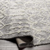 Close-up of the Dolo Area Rug, a cream and gray polyester rug with a textured, geometric pattern. Fold