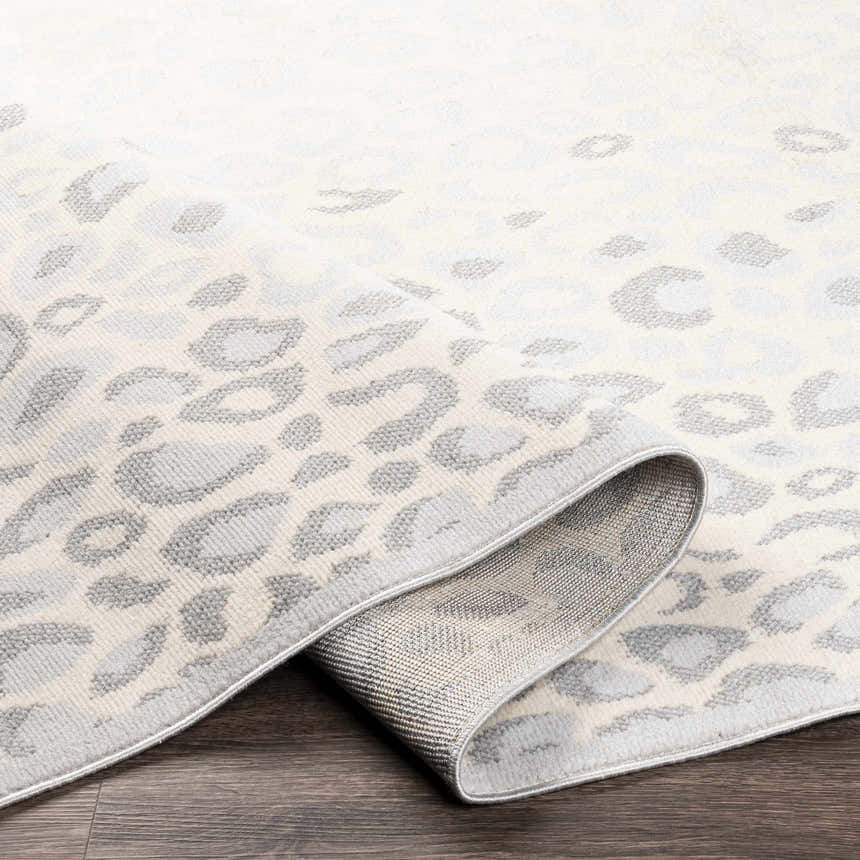 Close-up of the Delphia Cheetah Print Area Rug showing gray and oatmeal tones and animal pattern. Fold