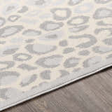 Close-up of the Delphia Cheetah Print Area Rug showing gray and oatmeal animal pattern and soft polypropylene texture. Texture