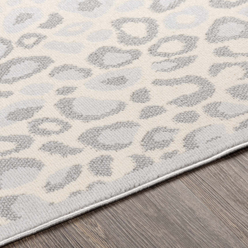 Close-up of the Delphia Cheetah Print Area Rug showing gray and oatmeal animal pattern and soft polypropylene texture. Texture