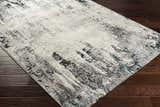 Close-up of the contemporary Dumangas Area Rug. Black, charcoal, cream, and gray abstract pattern. Corner