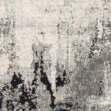Close-up of the Dumangas Area Rug featuring a contemporary black, charcoal, cream, and gray abstract pattern. Swatch