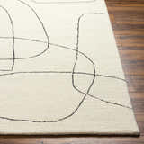 Close-up of Deniz Modern Off-White Wool Rug showing its abstract black line design and plush texture on a wood floor. Front