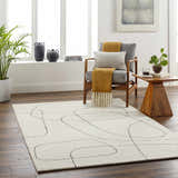 Living room scene with Deniz Modern Off-White Wool Rug, gray chair with throws, wood side table, and dark wood floors. Roomscene-Rectangle